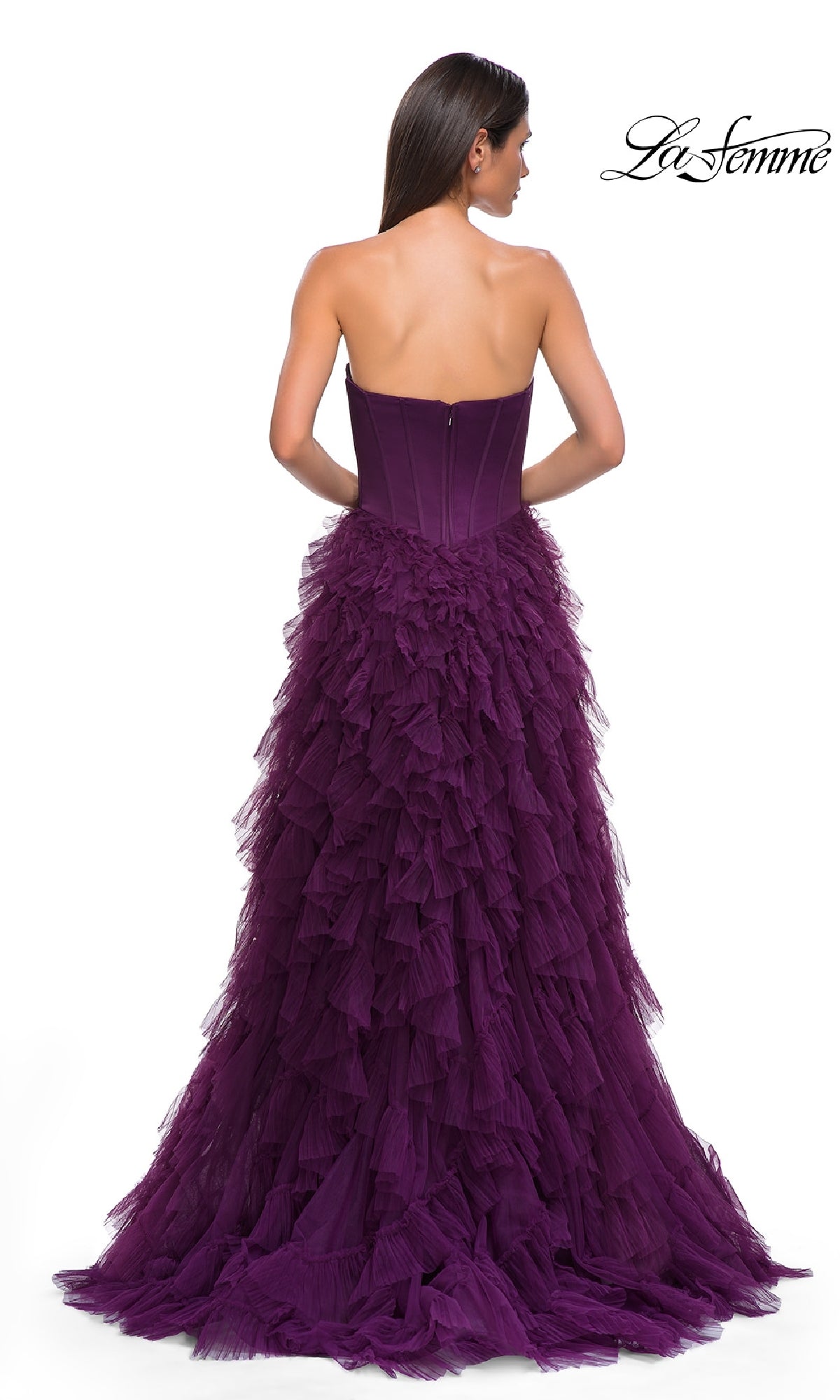 A woman faces away in the La Femme 32760 Strapless Long Ruffled Prom Dress, a deep purple A-line gown with a corset bodice and tulle skirt, posed against a white background. The La Femme logo is shown in the top right corner.